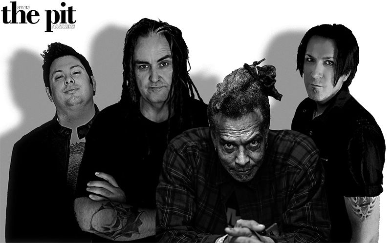 Four men posing with serious expressions, two with tattoos, one in grayscale; black backdrop with "Primitive Race" logo at the top left.