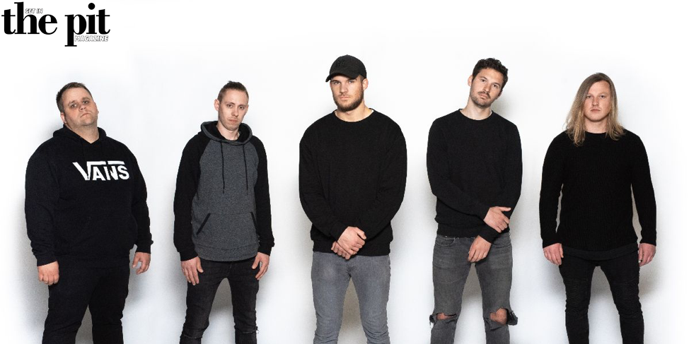 Five men standing against a white background, three wearing black tops and two in hoodies, with serious expressions. They are members of Rising Insane.