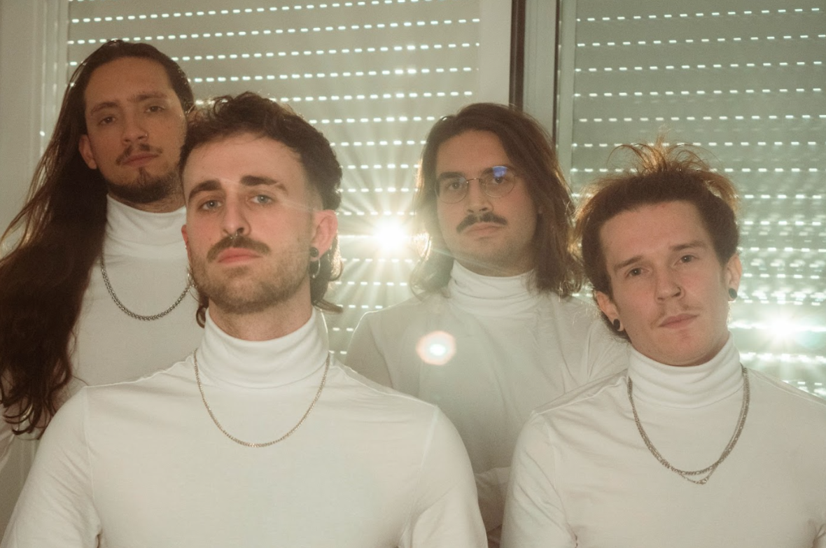 Four men in white turtlenecks and necklaces, standing in a row with a softly lit background, looking intently at the camera, adorned with Acid Snot accessories.