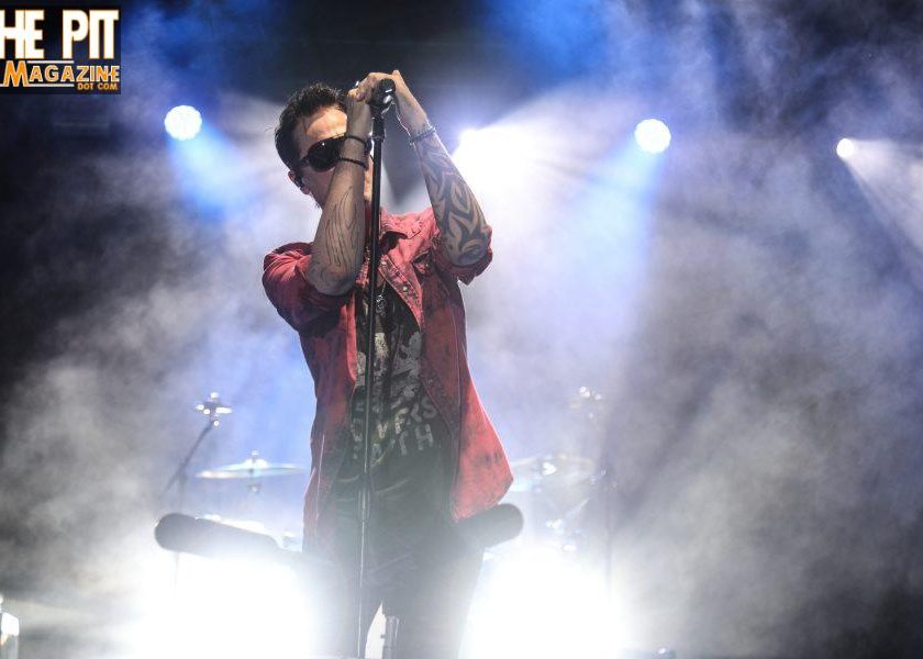 Four men posing for a band photo with 'Get in the Pit Magazine' text.